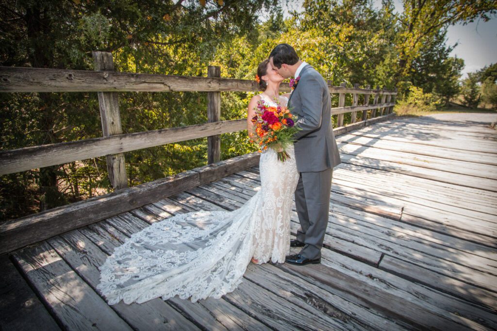 Chad and Jessie share a kiss on a wooden bridge