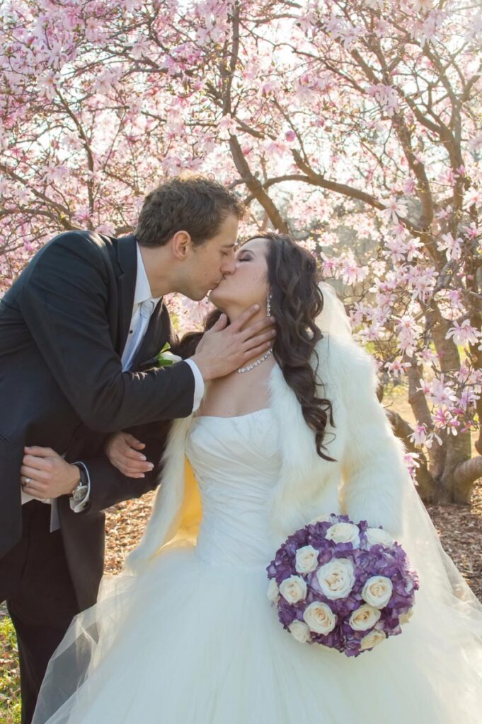 Sarah and Nathan kissing sweetly under a flowering tree