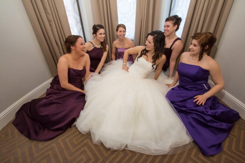 Sarah laughing on the floor with her bridesmaids