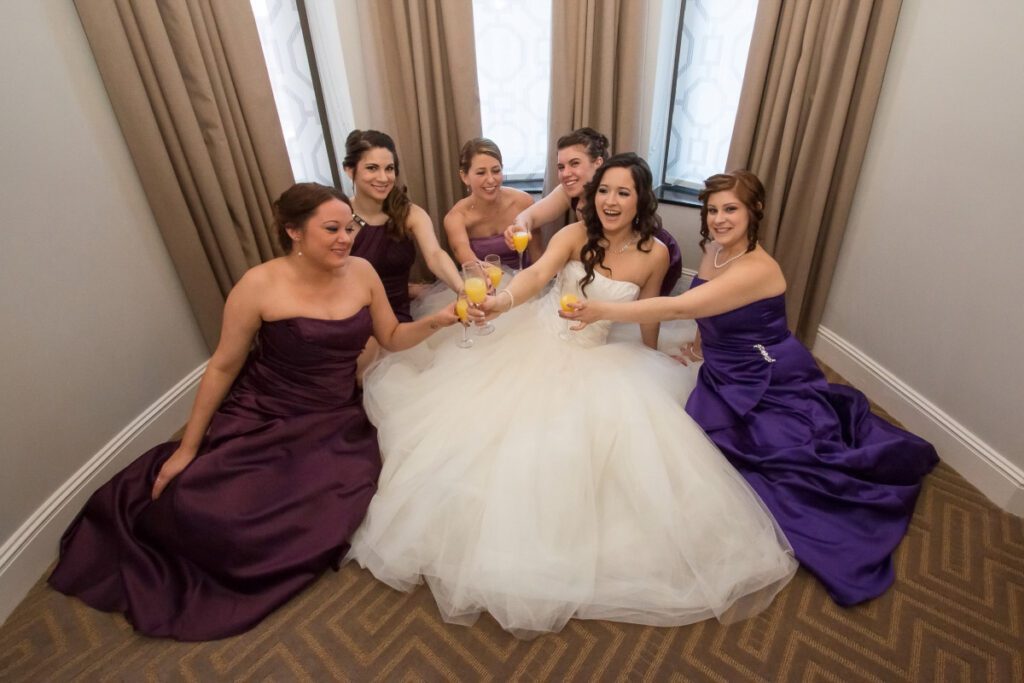 Sarah and her bridesmaids making a toast on the floor