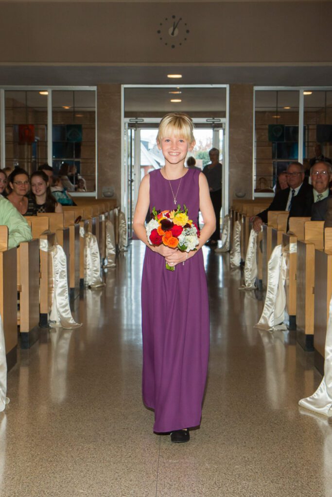 A girl in a purple dress holding flowers