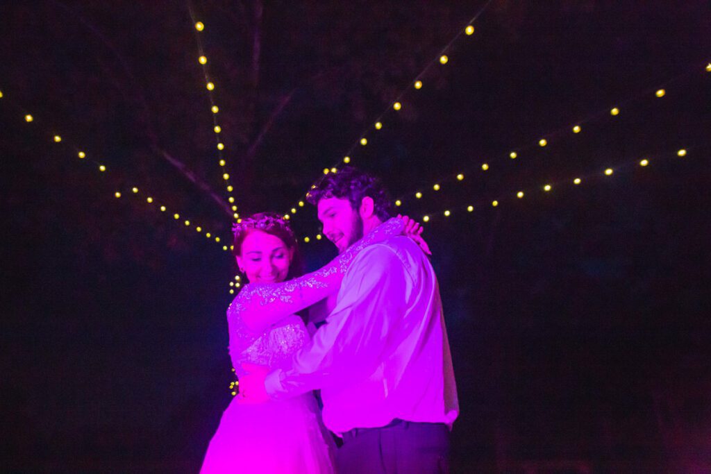 Nicole and Christian dancing under a purple light
