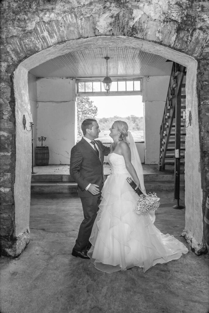 A black and white image of Lindsey and Zach under a building