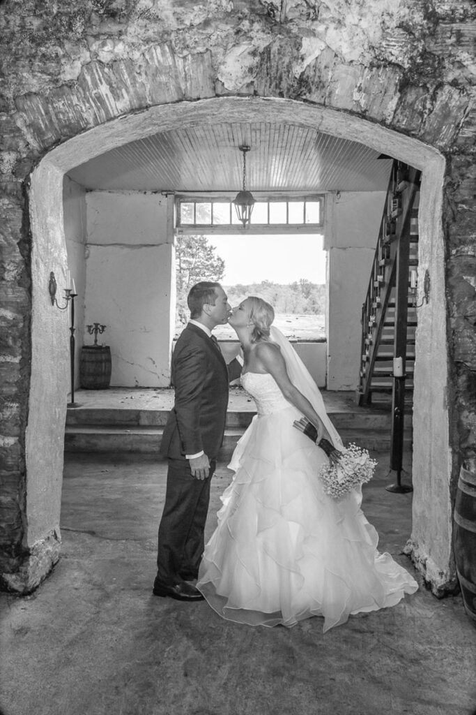 A grayscale image of Lindsey and Zach kissing in a building
