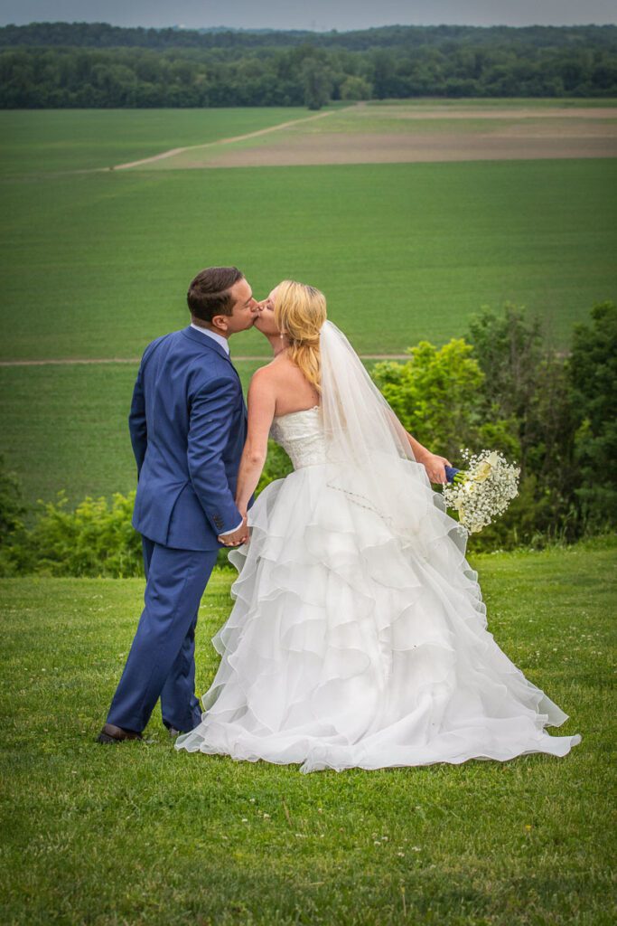 Lindsey and Zach kissing on a hill