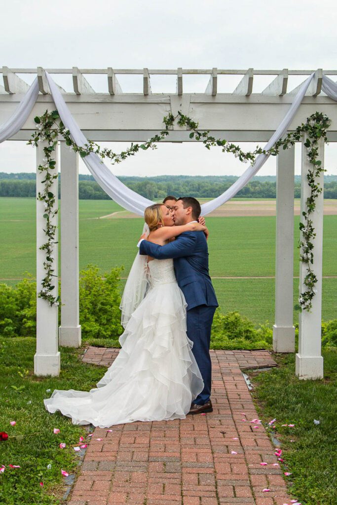 Lindsey and Zach kissing at the wedding arch