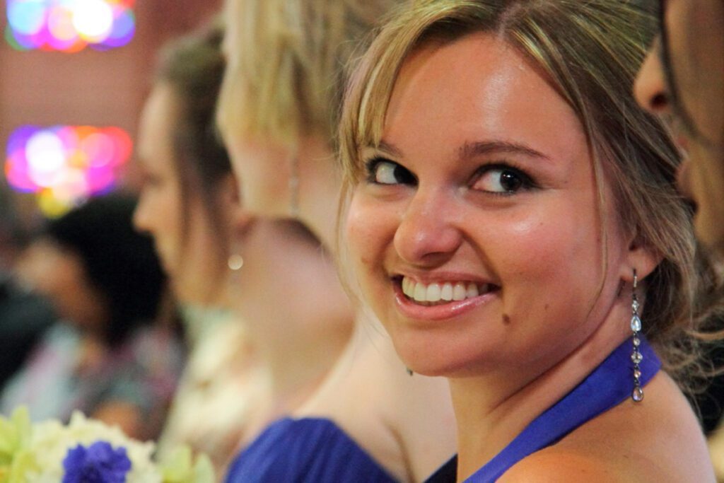 A bridesmaid of Alice smiling