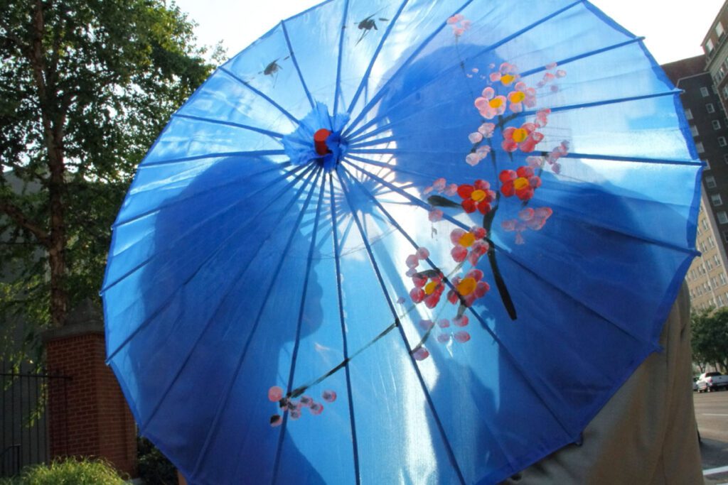 Alice and Joe behind a blue umbrella