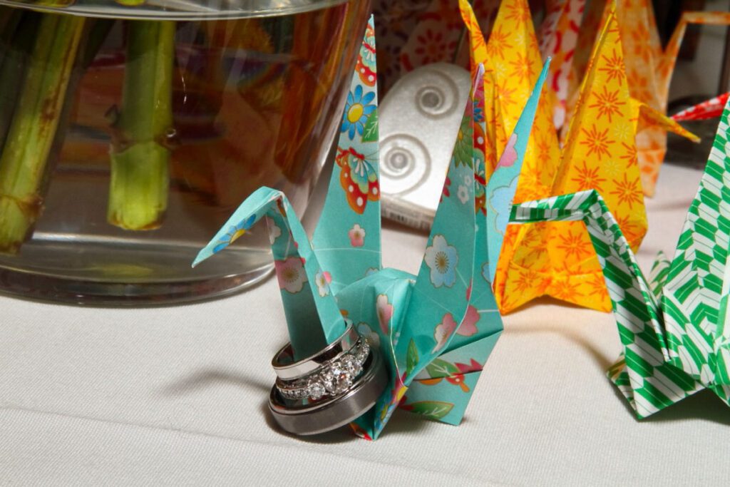 An origami holding the wedding rings of Alice and Joe