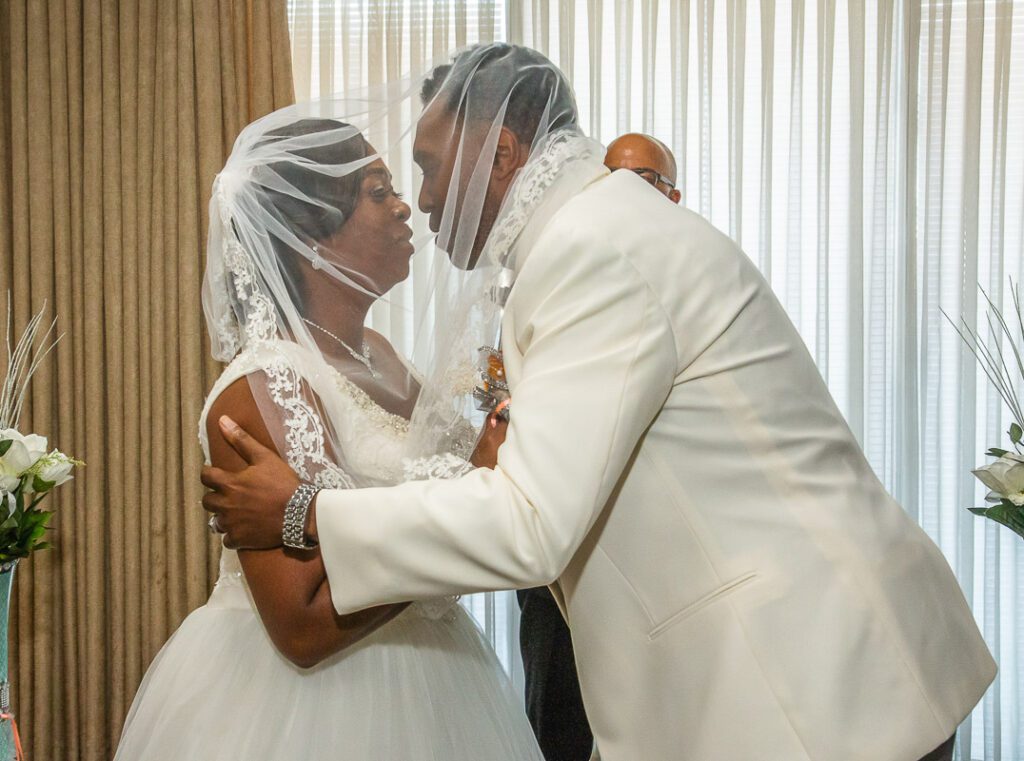 Rhonda and Tyrone about to kiss under the veil