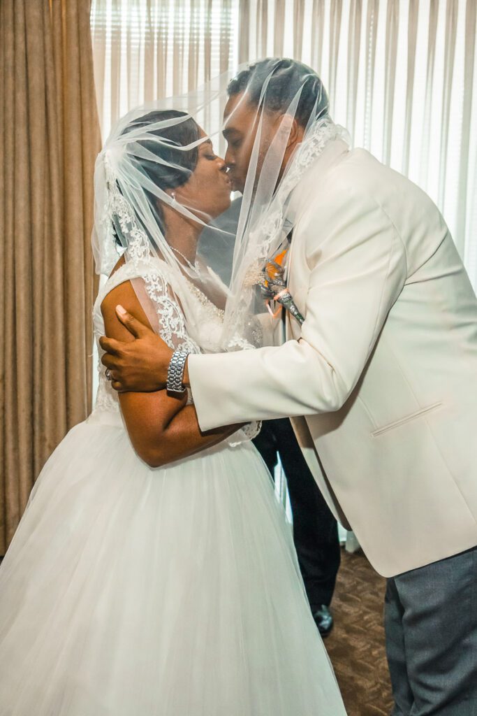 Rhonda and Tyrone kissing under the veil