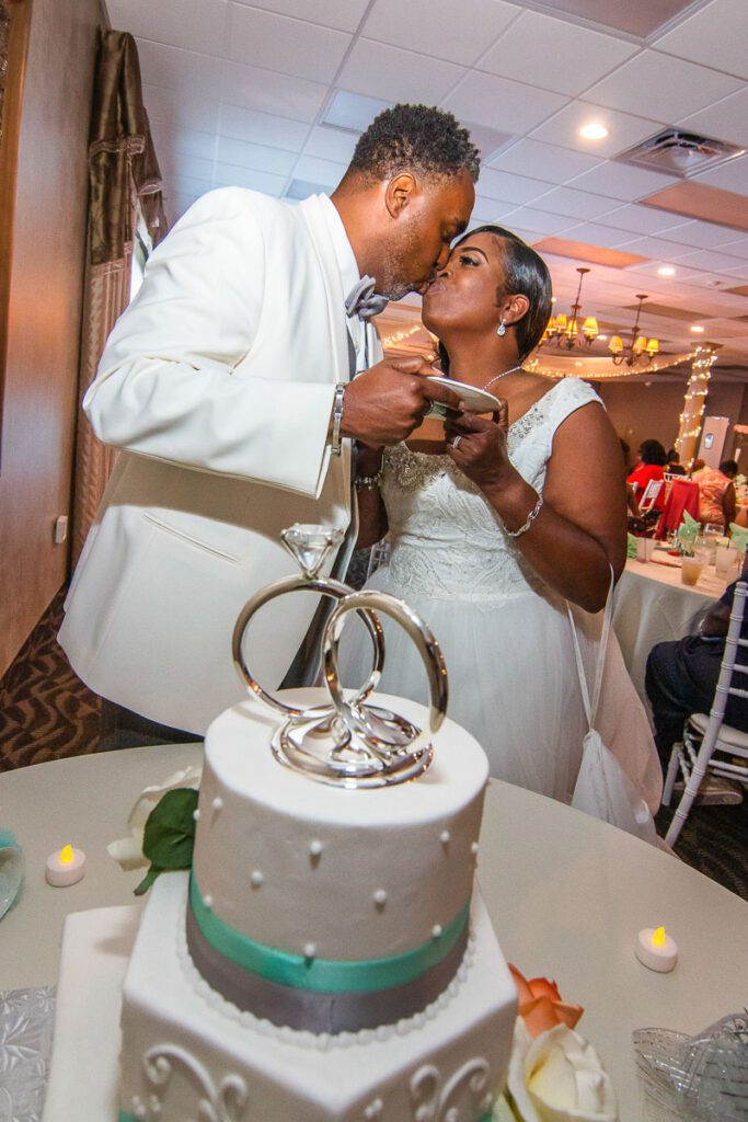 Tyrone and Rhonda kiss before slicing the cake
