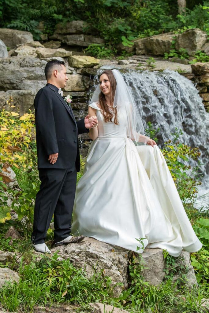 Amanda and Joe holding hands next to a small waterfall