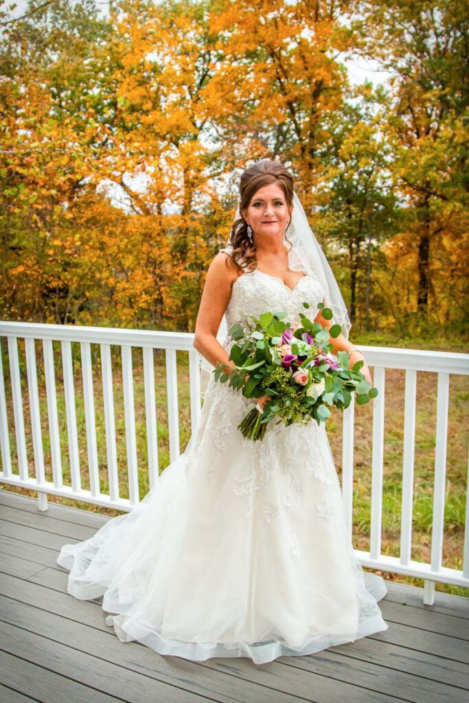 Nicole in her white wedding dress and large flower bouquet