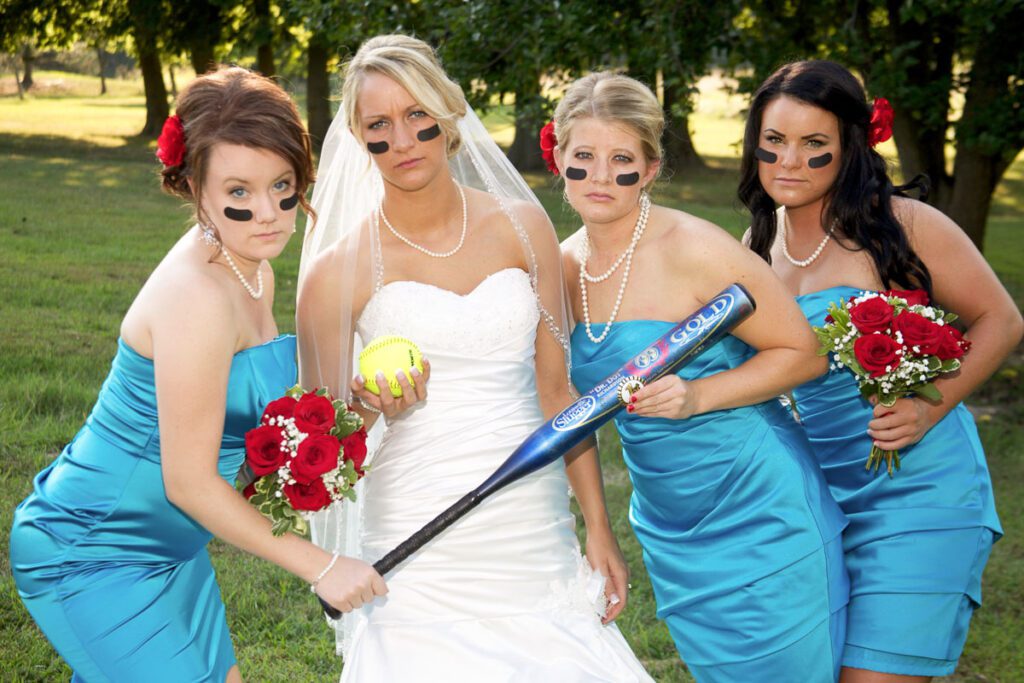 A bride and her bridesmaids holding a bat and a ball