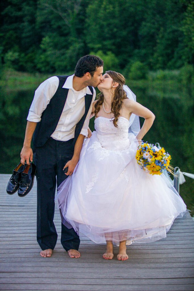 A bride and groom kissing on a pier