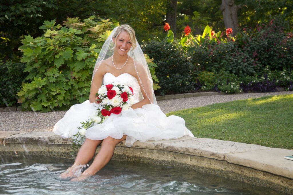 A bride dipping her feet in a fountain
