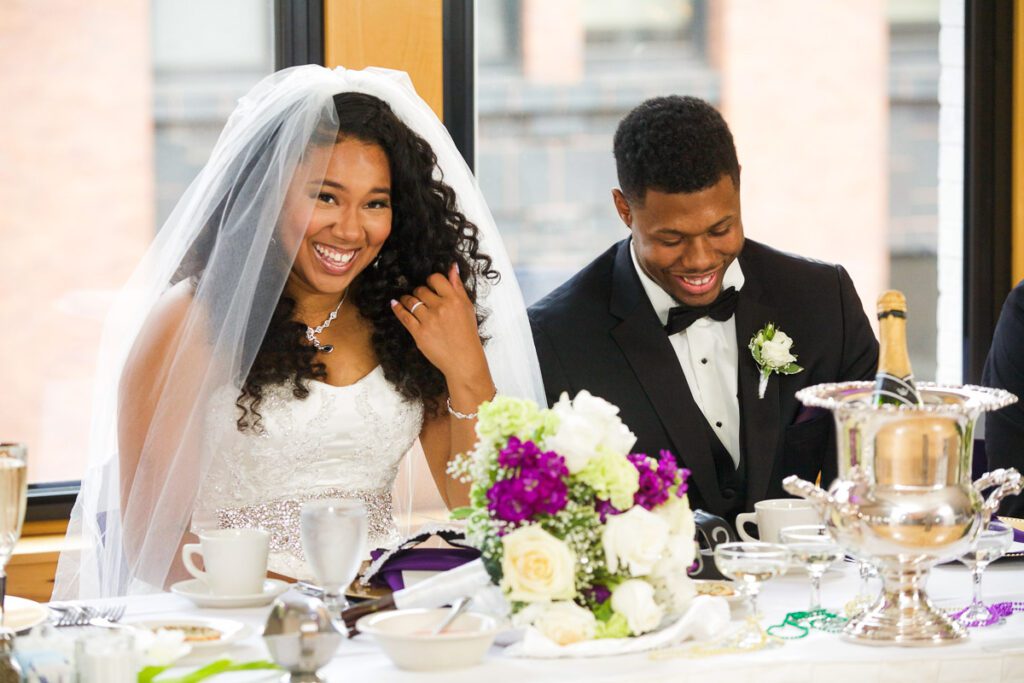 The bride and groom laugh as they sit at their table