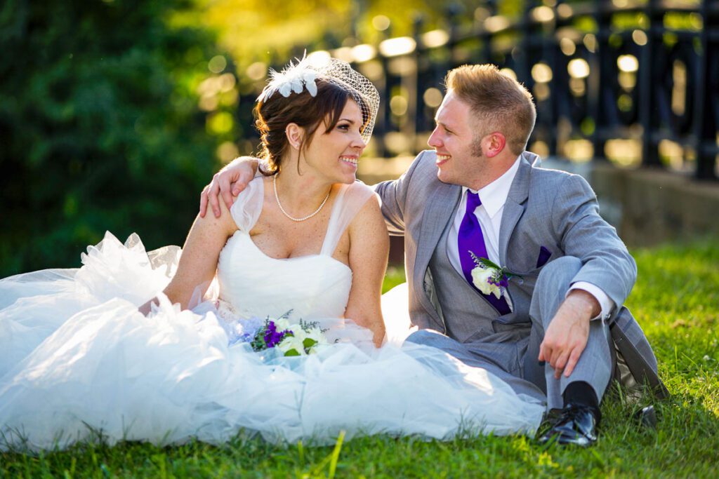 The bride and groom sitting on a lawn