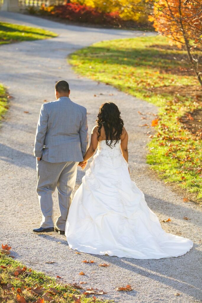 The bride and groom walking down a path while holding hands