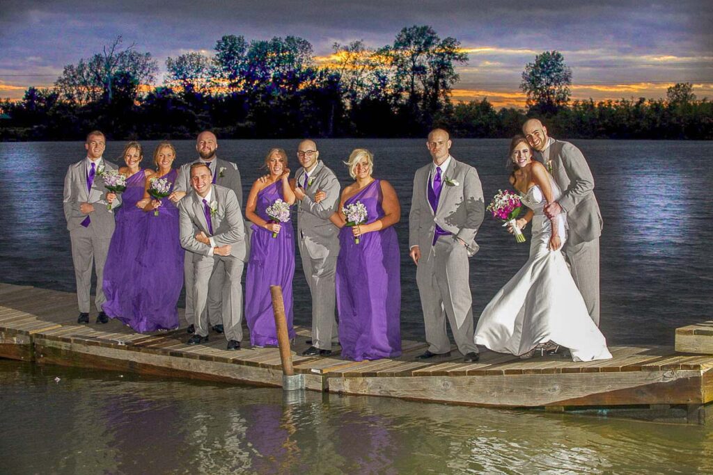 A filtered image of the bride and groom with their attendants on a floating pier