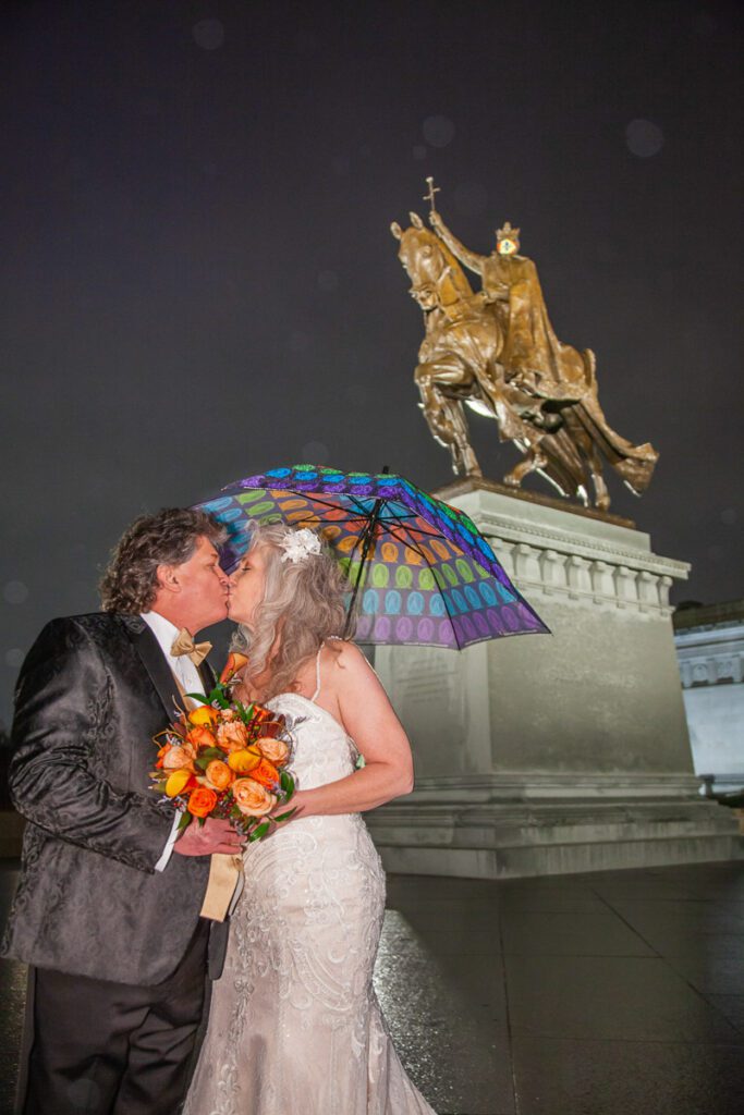 Christie and Les kiss under an umbrella