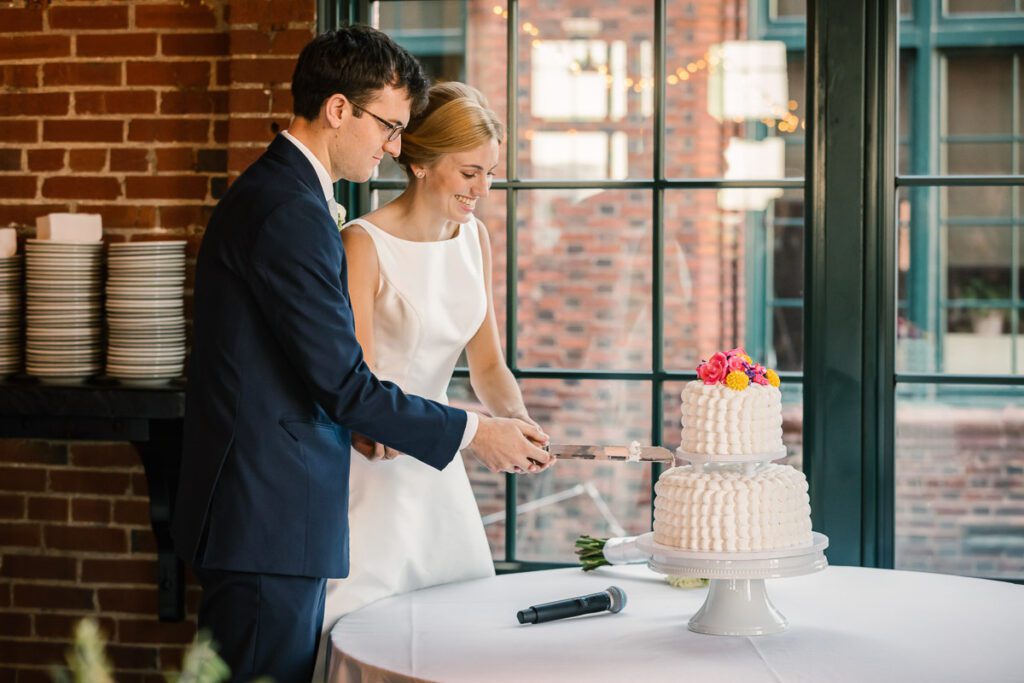 Laura and John slicing their wedding cake