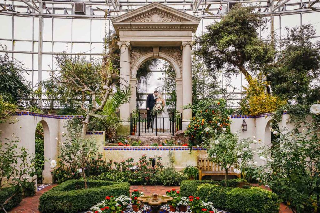 The bride and groom kissing in a garden arch