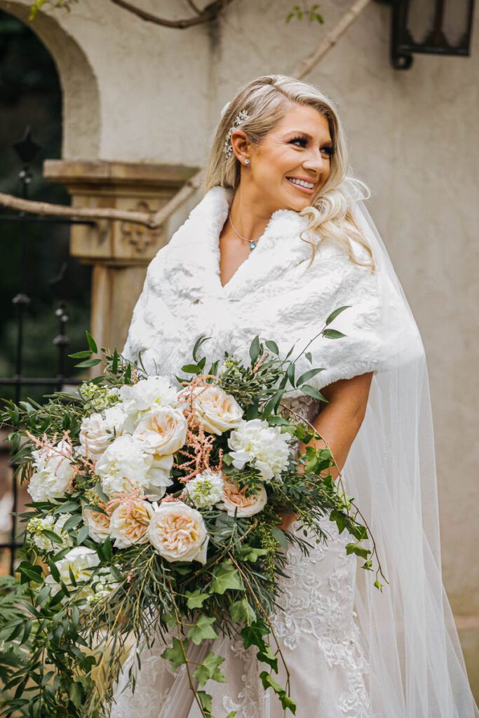 A bride holding a large bouquet of white roses