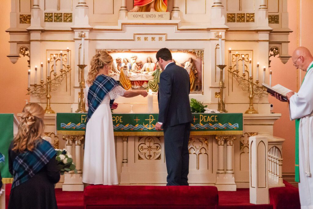 Ariana and Zach lighting candles at the altar