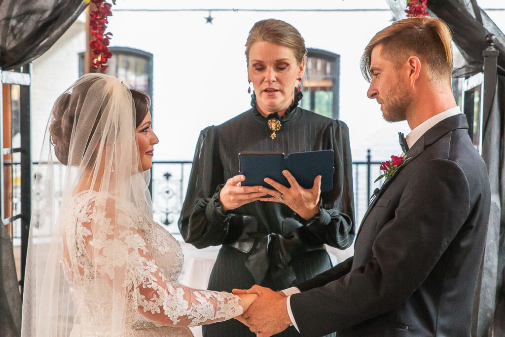 Gwyn and Shaun holding their hands while exchanging vows