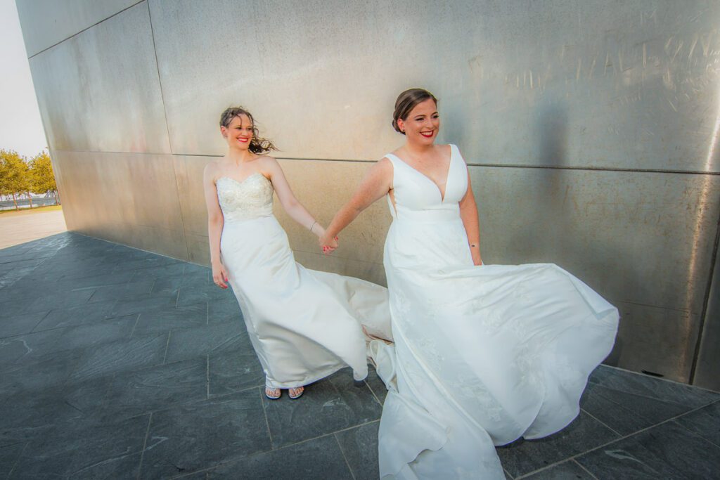 The brides holding hands on a windy day