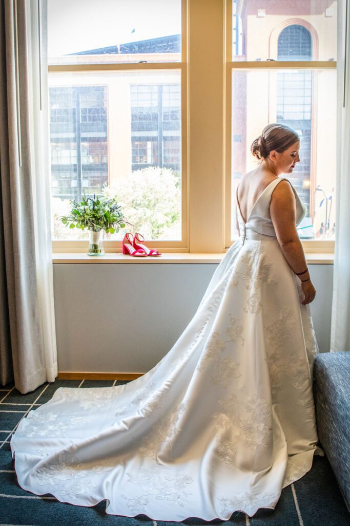 A bride by the window wearing her wedding dress
