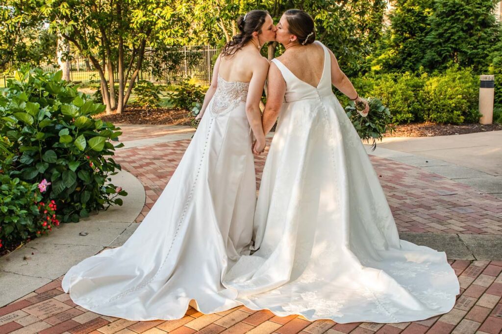Brides sharing a kiss along a brick road