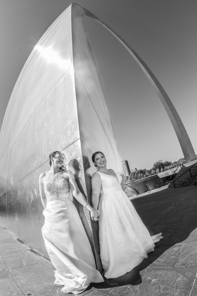 Brides holding hands at the base of the Gateway Arch