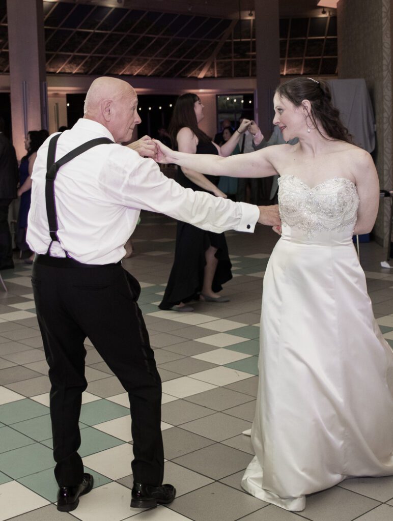 A bride dancing with her father on the floor