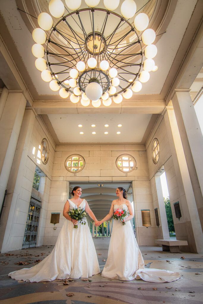 Julianne and Annie holding hands under a large chandelier