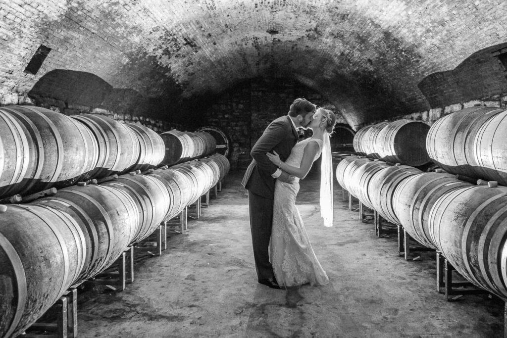 A black and white image of the bride and groom kissing