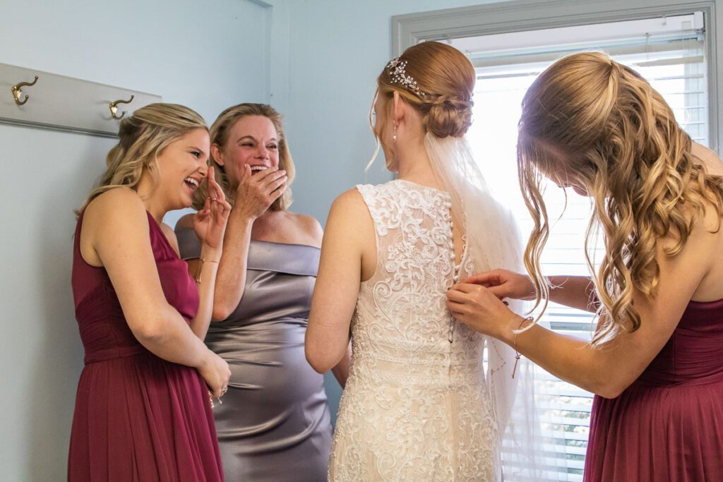 A bride laughing with her bridesmaids