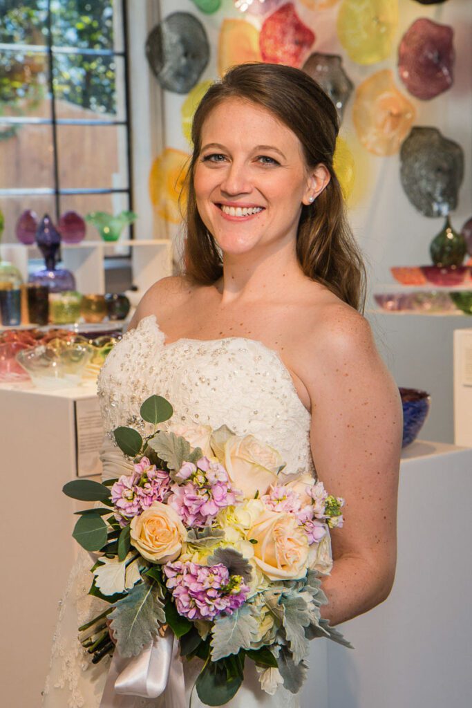 A bride holding her bouquet of flowers smiling