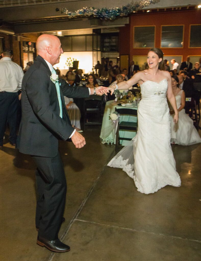 One of the brides about to dance with her father