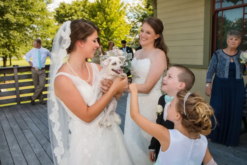 A bride holding a dog next to kids