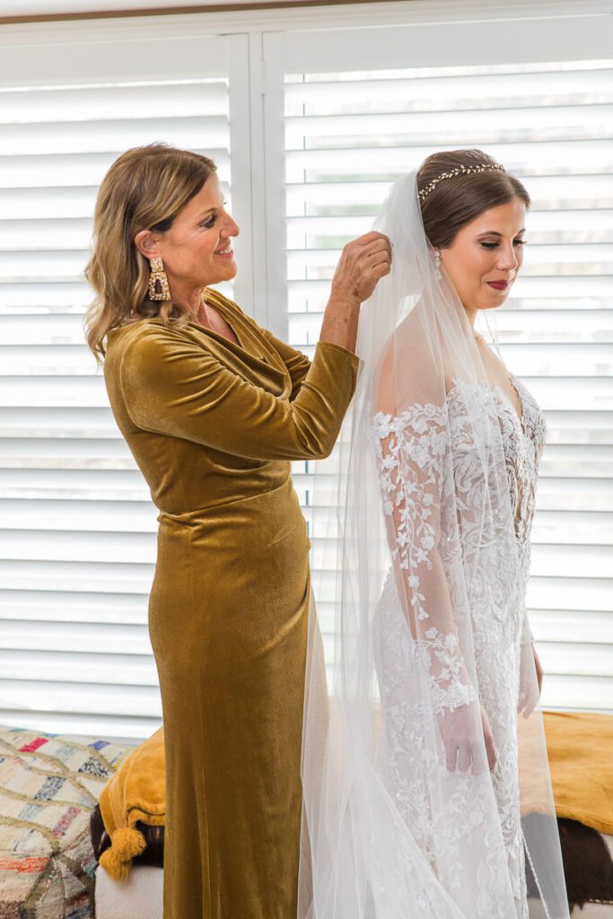 Julia putting on her veil with the help of her mom