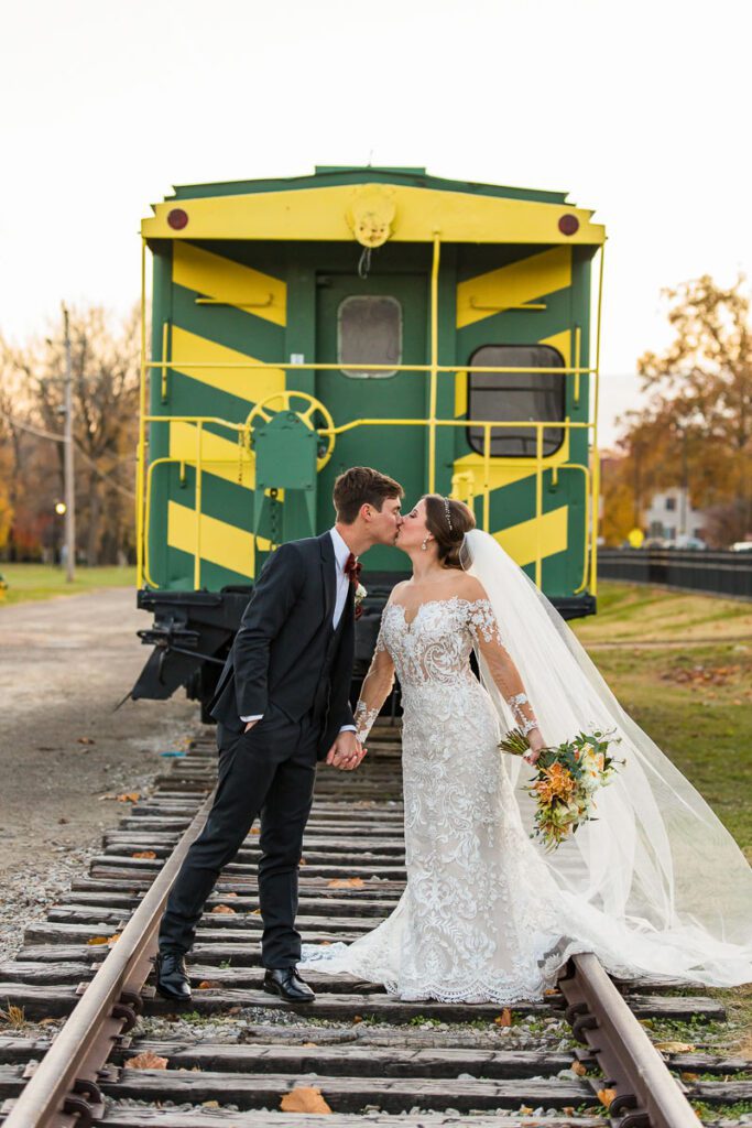Julia and Chris kissing in front of a train