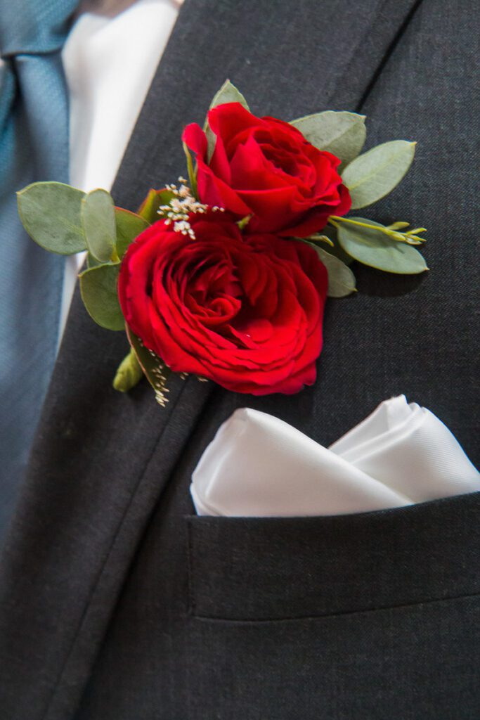 A red boutonniere on the coat
