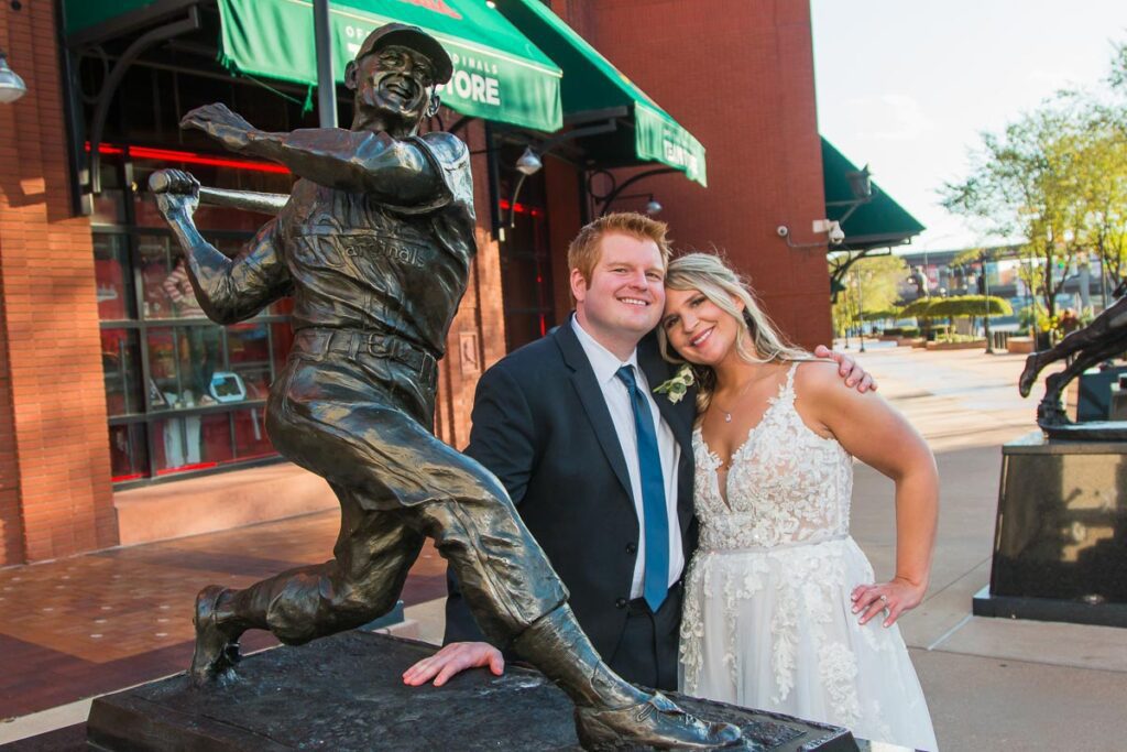 Brian and Justine next to a statue of a baseball player