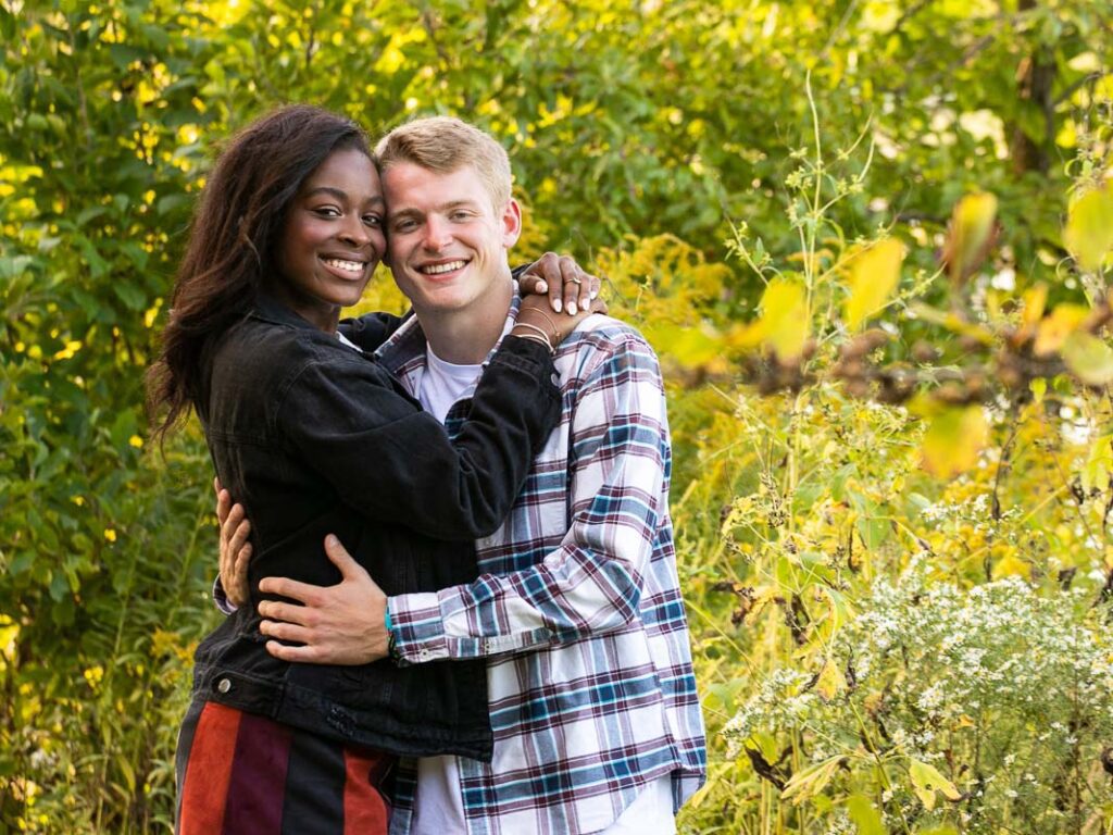 A black woman and a white man hugging each other