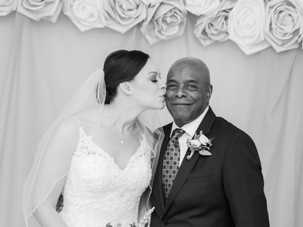 A bride kissing the cheek of her father