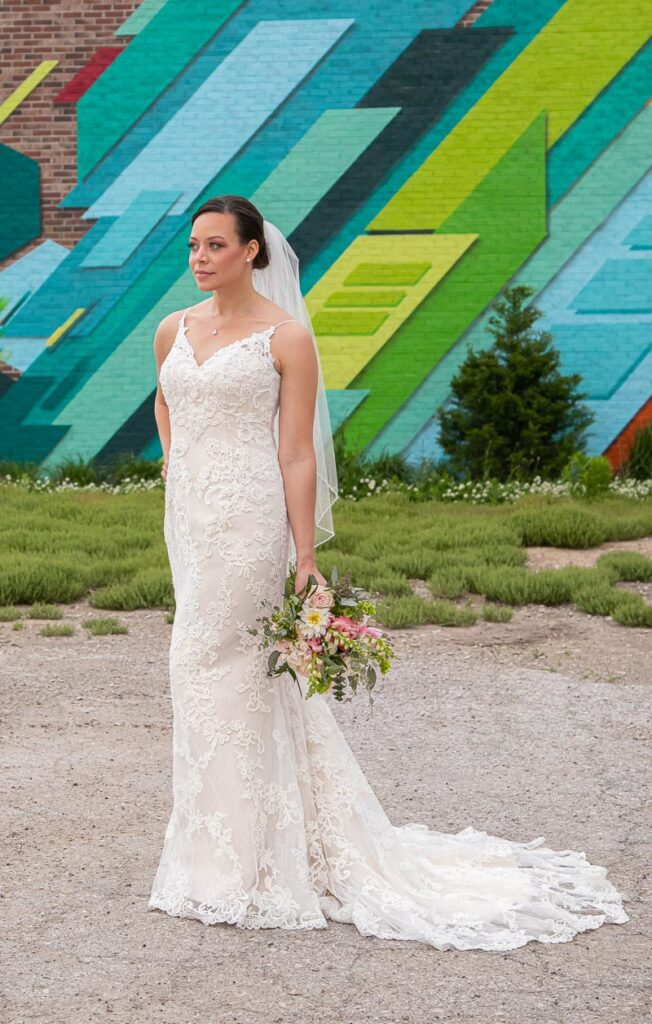 A bride in front of a colorful brick wall