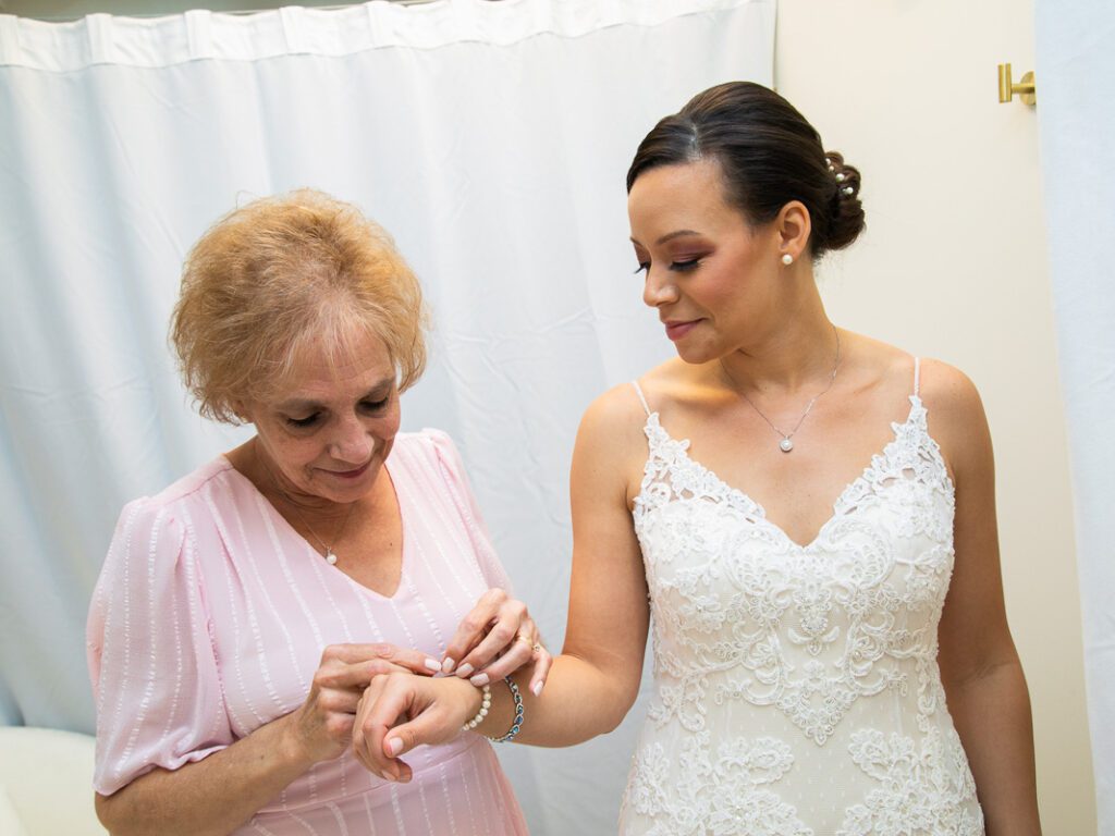 An old woman putting a bracelet on the bride’s wrist